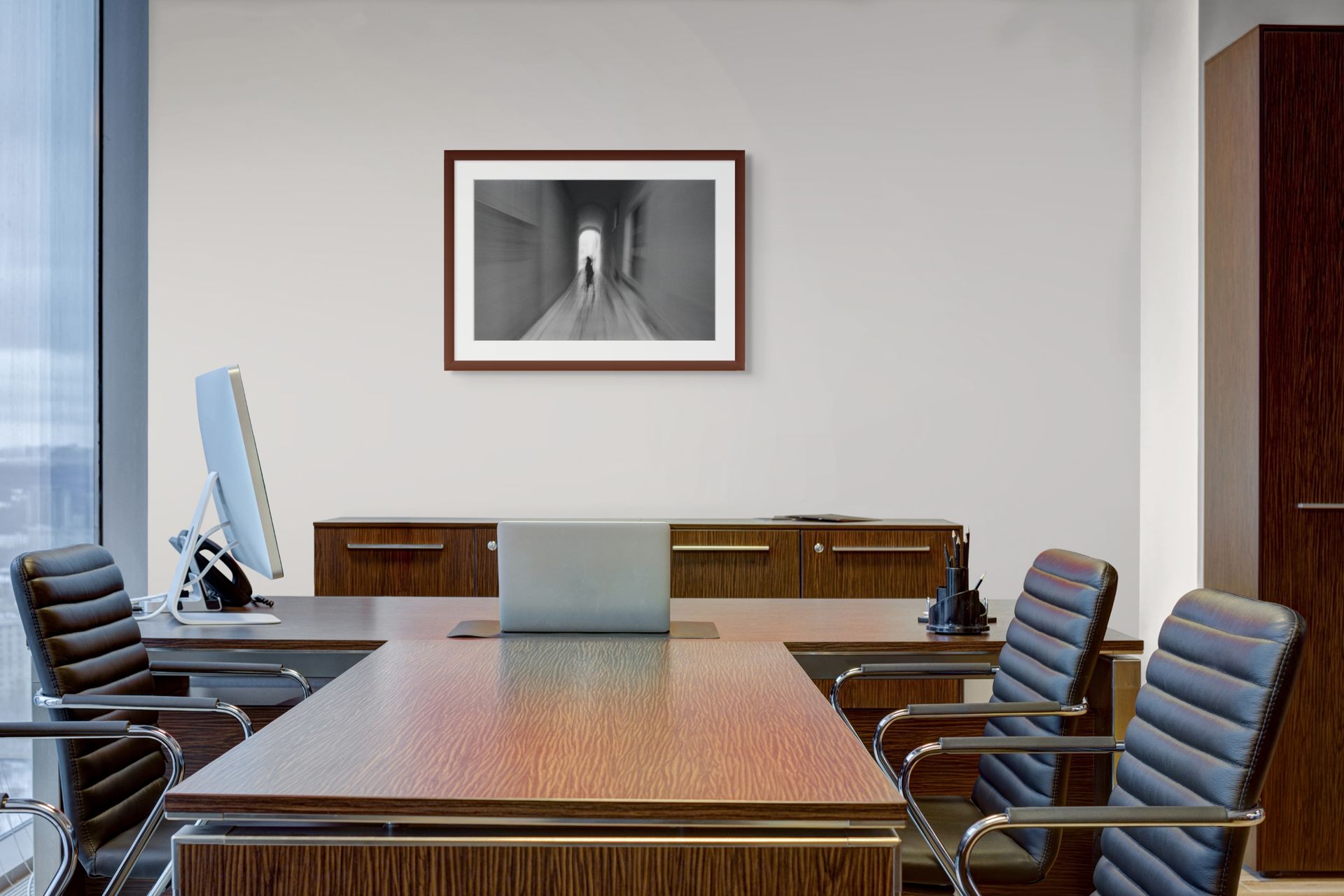 A classic black and white abstract photo hung on the wall and framed in an office interior.