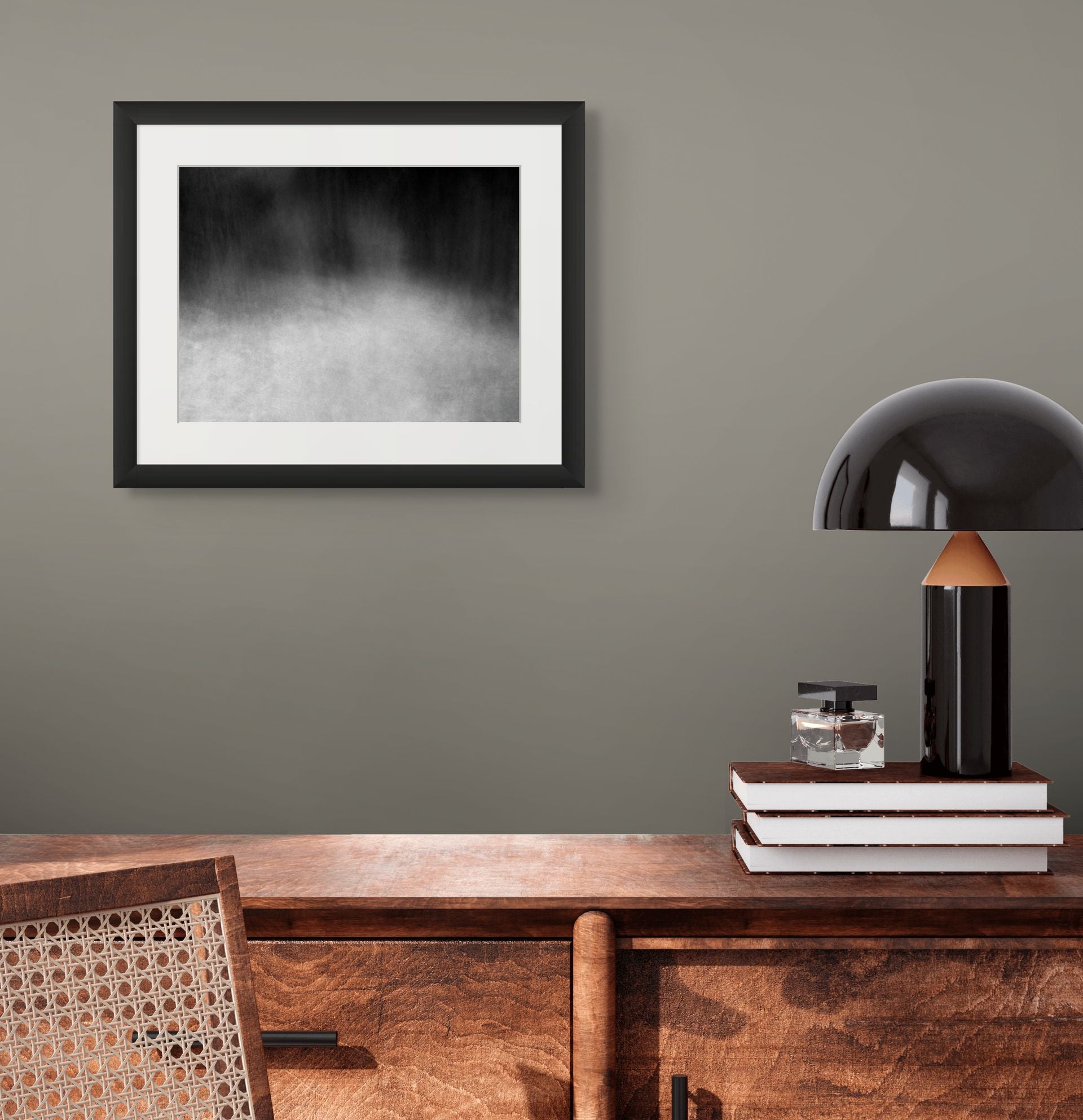 An abstract photo of the woods shot in black and white, framed and hanging on the wall of an office.