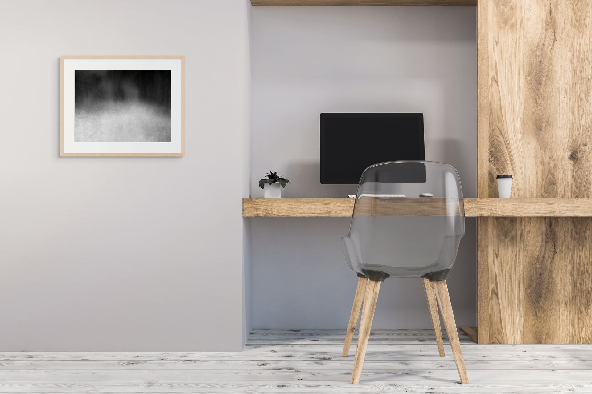 An abstract photo of the woods shot in black and white, framed and hanging on the wall of an office.