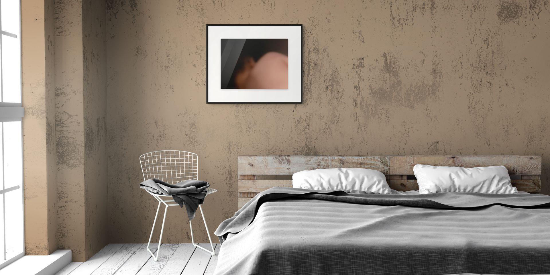 A fine art photo print of a body in the dark, hanging on the wall of a bedroom.