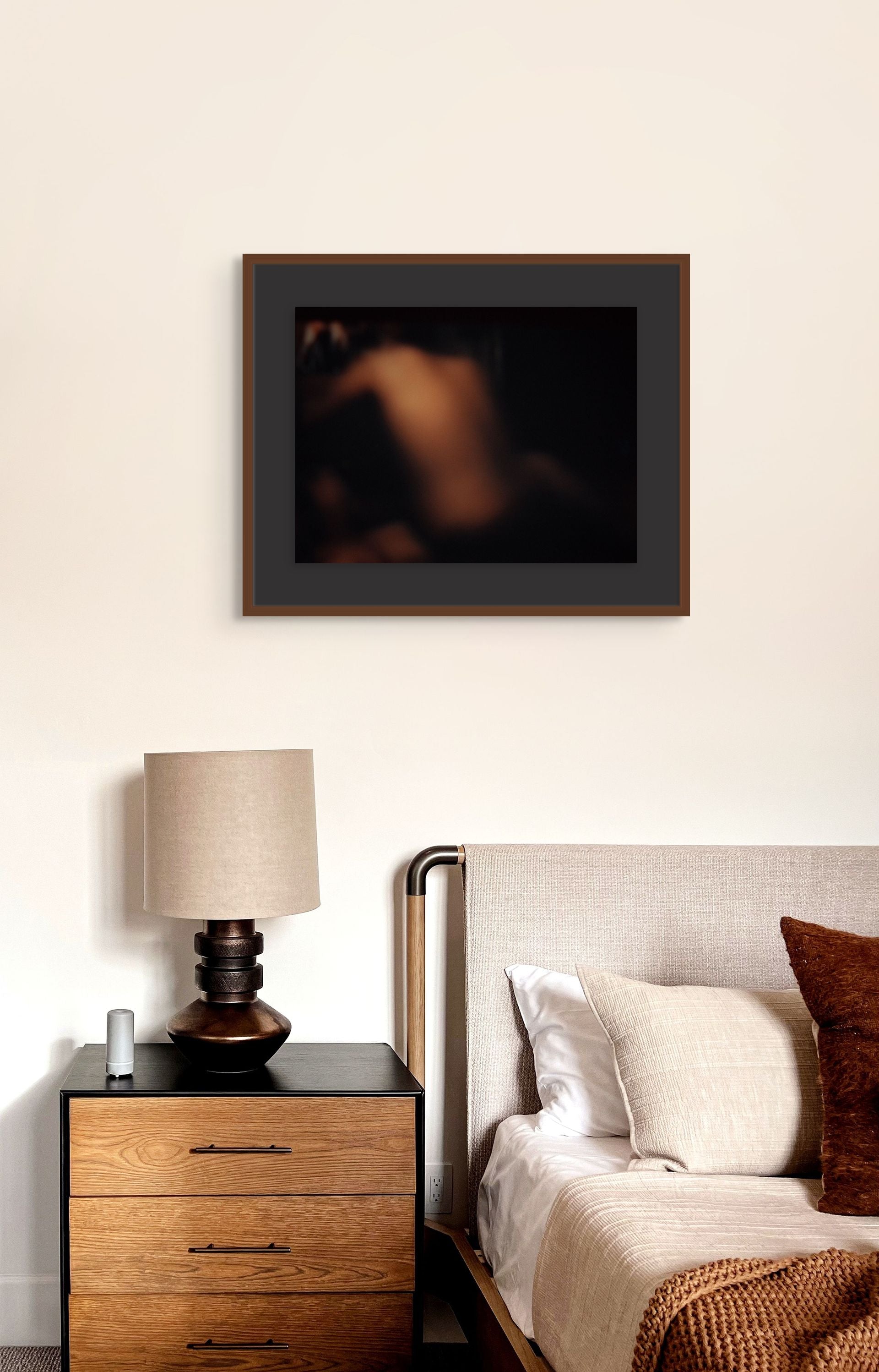 Printed on fine art paper, an abstract photo hangs on the wall of a modern bedroom.