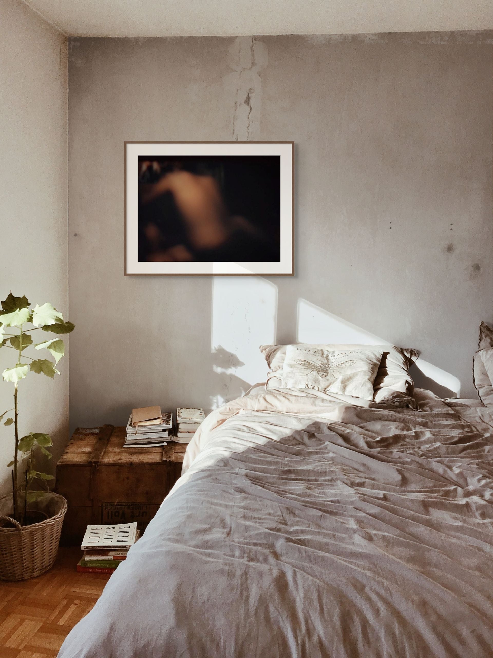 Printed on fine art paper, an abstract photo hangs on the wall of a modern bedroom.