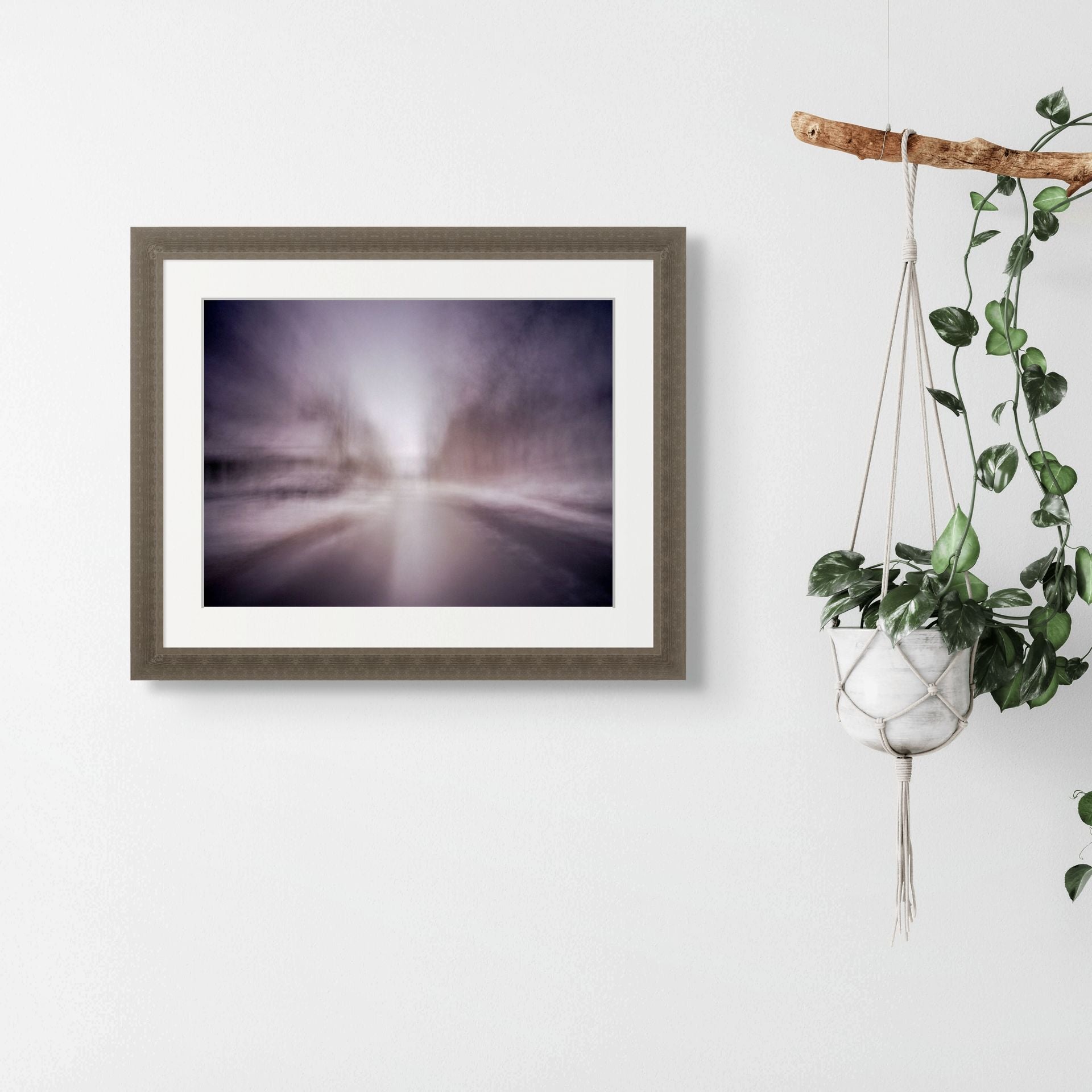 An abstract fine art print of a snowy landscape, framed and hung on the wall of a modern space.