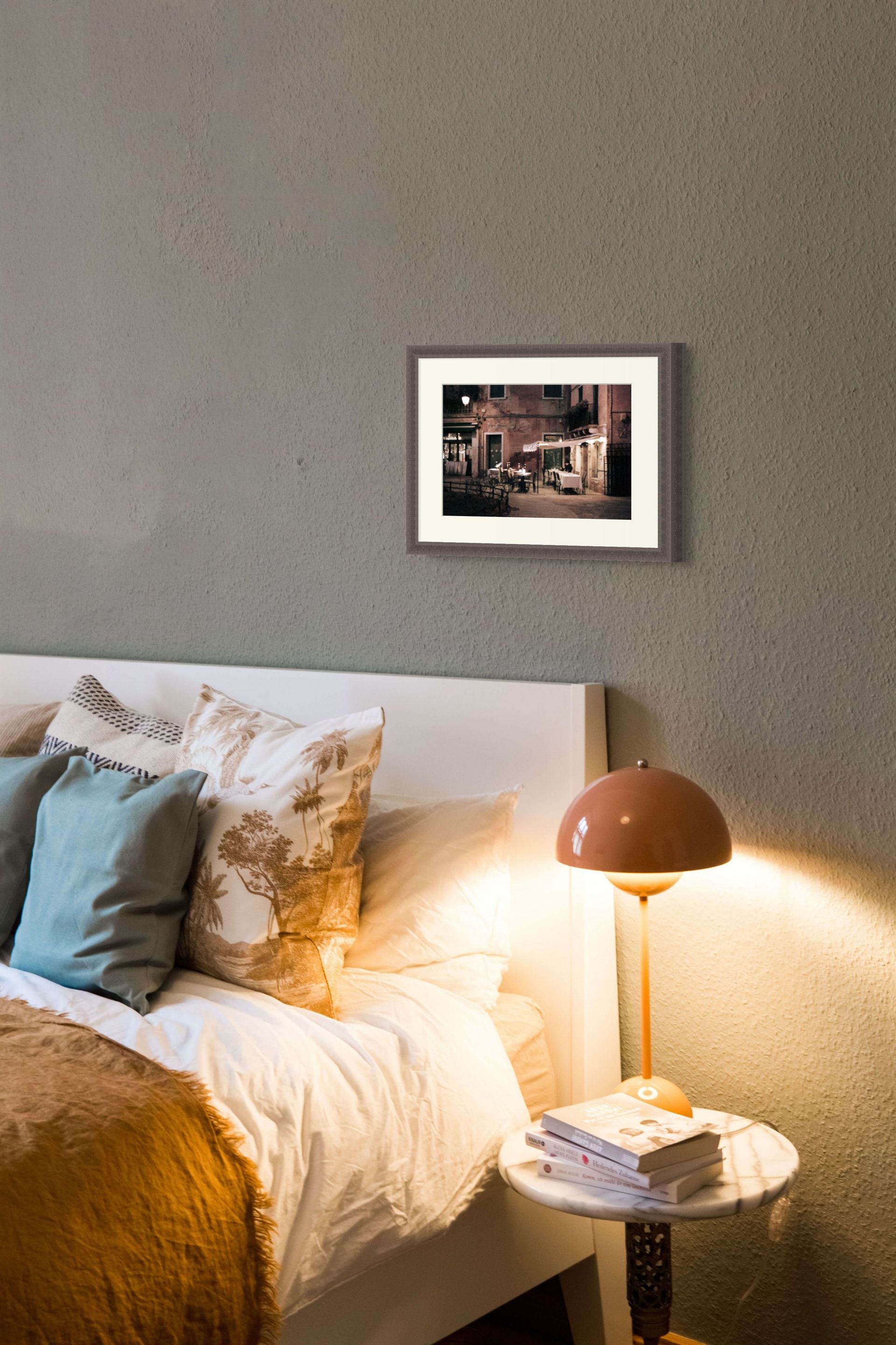 Bedroom interior with a framed fine art print of Venice at night. The picture is an abstract photo on giclee paper.