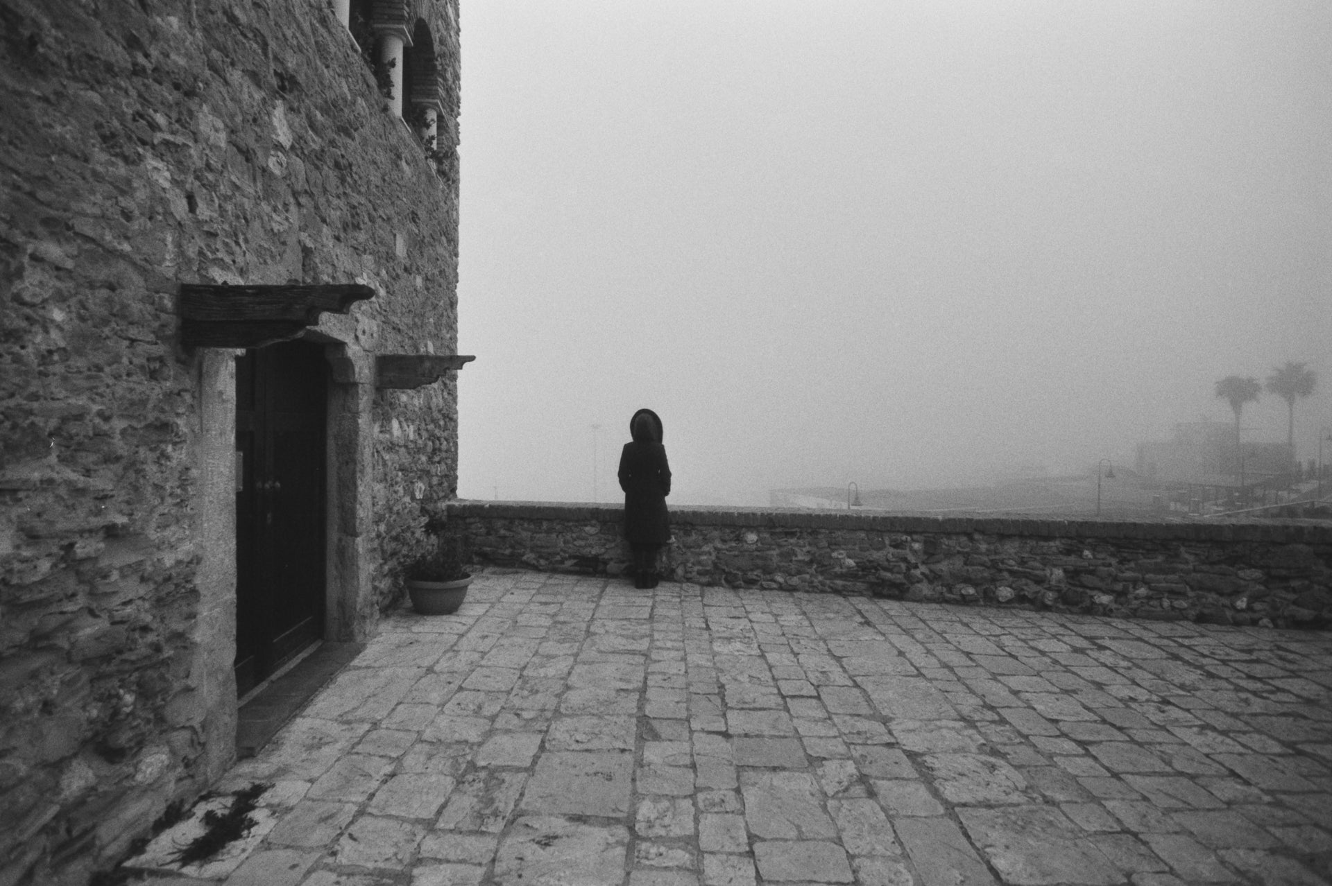 A misty fine art photo print on black and white ilford photo paper depicting a woman in Termoli, Italy.