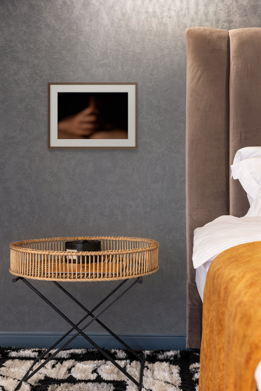 A print of an abstract photo, framed in black and hanging in a modern bedroom.