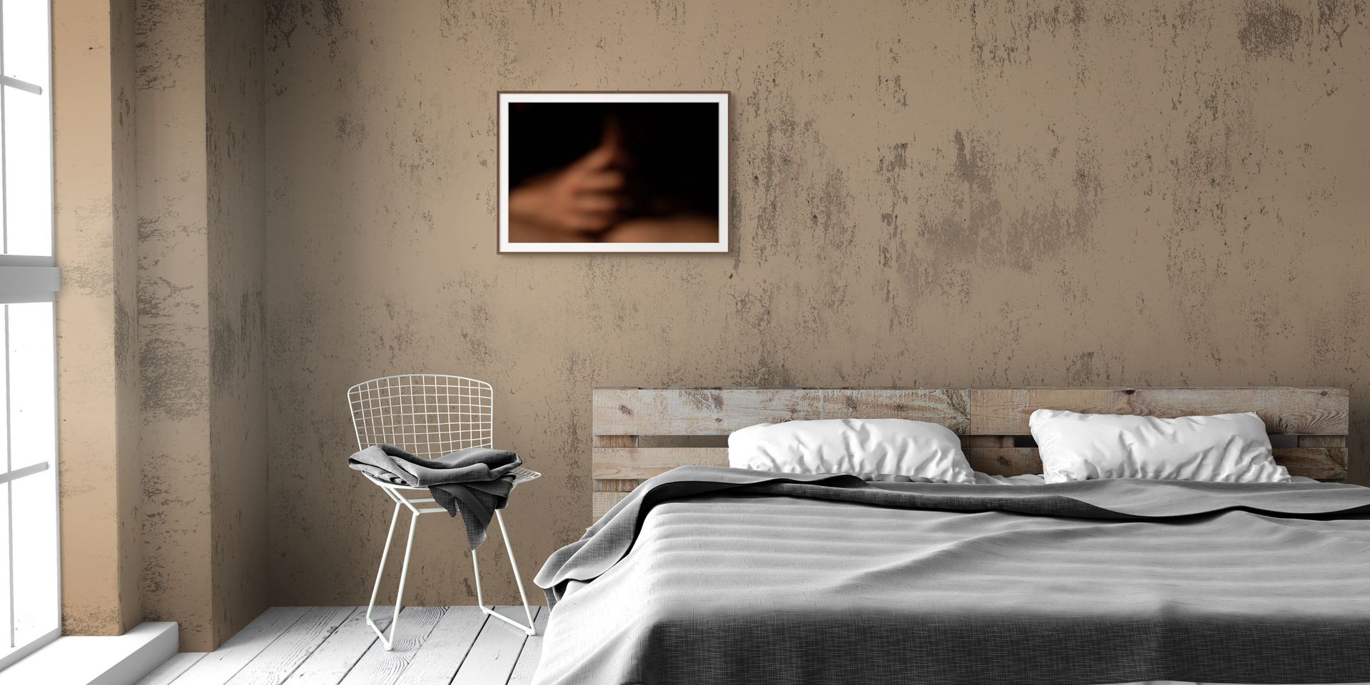 A print of an abstract photo, framed in black and hanging in a modern natural bedroom.